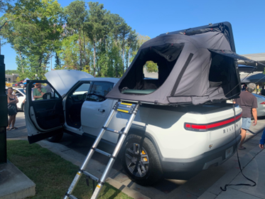 Rivian electric adventure truck with attached truck topper camper